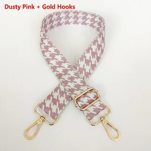 Detail of houndstooth jacquard bag strap in dusty pink with gold rotating metal hooks