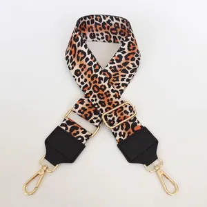 Detail of leopard print bag strap with golden lobster clasps and black leather accents