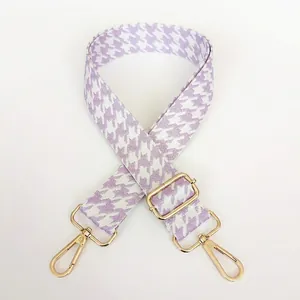 Close-up of adjustable purple houndstooth wide strap with golden metal swivel hooks