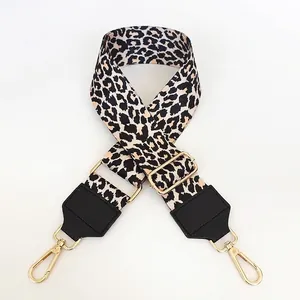 Close-up of adjustable leopard print bag strap with golden metal carabiners