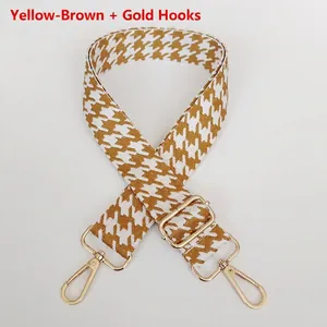 Detail of yellow brown houndstooth bag strap with adjustable gold metal lobster clasps