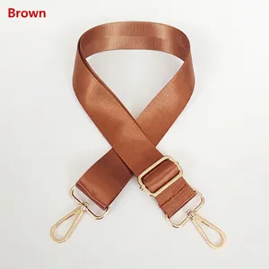 Detail view of brown nylon shoulder strap with gold-tone hardware and lobster hooks