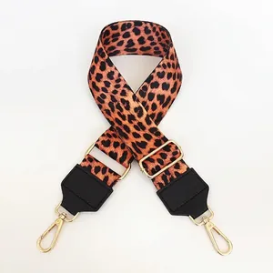 Close-up of leopard print bag strap with adjustable gold buckle and black leather ends