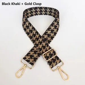 Close-up of black and khaki houndstooth bag strap with gold metal swivel hooks