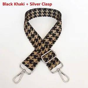 Detail of houndstooth jacquard bag strap in khaki and black with silver metal hooks