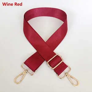Detail of adjustable wine red nylon bag strap with polished gold metal swivel hooks