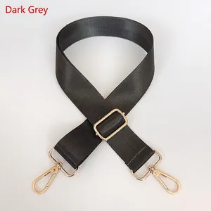 Detail of adjustable dark grey nylon strap with polished gold-tone metal snap hooks