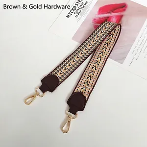 Close-up of ethnic geometric woven strap with brown leather and gold swivel snap hooks