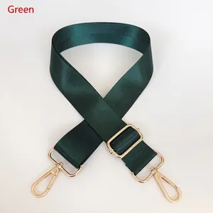 Detail of adjustable dark green nylon bag strap with high-quality gold metal lobster hooks