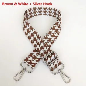 Detail of coffee houndstooth strap with silver metal swivel hooks and adjuster