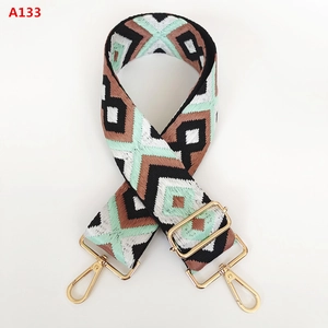 Detail view of woven bohemian geometric diamond pattern bag strap with gold metal hooks