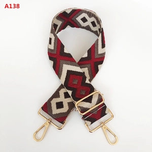 Detail of red and grey diamond pattern jacquard strap with gold metal hooks