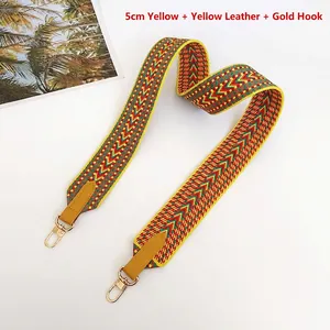 Detail view of 5cm wide woven yellow red and green strap with gold metal hooks