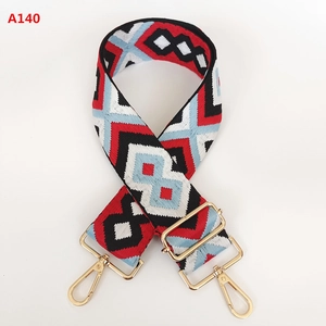Close-up of geometric jacquard bag strap with golden metal swivel hooks and adjustable buckle