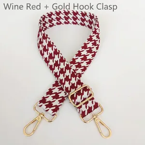 Detail of wine red houndstooth jacquard bag strap with polished gold metal swivel hooks