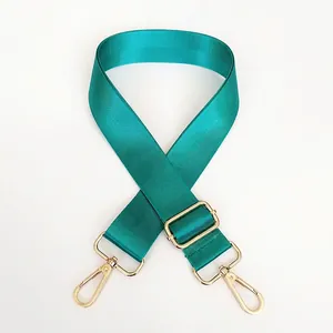 Detail of light green nylon shoulder strap with polished gold-tone metal lobster clasps