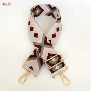 Détail de la bandoulière en jacquard géométrique avec mousquetons en métal doré