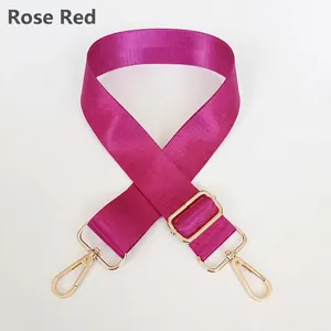 Close-up of rose red nylon strap with adjustable golden metal buckle and swivel hooks