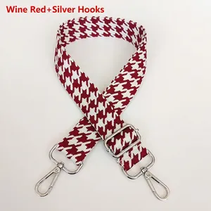 Detail of wine red houndstooth wide bag strap with silver metal swivel hooks
