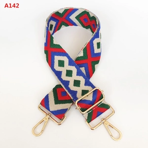 Detail of colorful geometric jacquard wide bag strap with gold metal lobster clasps