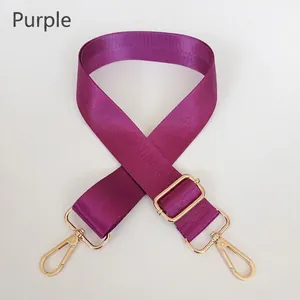 Close-up of adjustable purple nylon shoulder strap with golden metal hardware clips