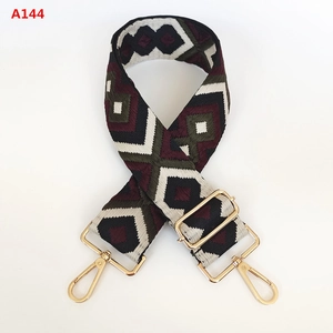 Close-up of geometric jacquard bag strap with golden metal clips and adjuster