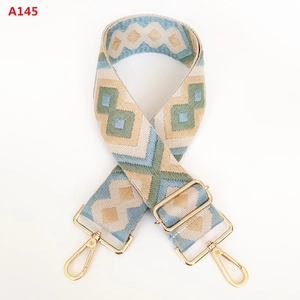 Macro detail of geometric diamond pattern canvas bag strap with golden alloy hooks