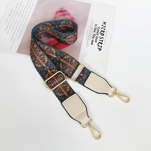 Detail of bohemian woven bag strap with blue geometric patterns and golden metal clasps