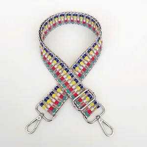 Detail of colorful geometric woven bag strap with silver metal swivel hooks and adjustable buckle
