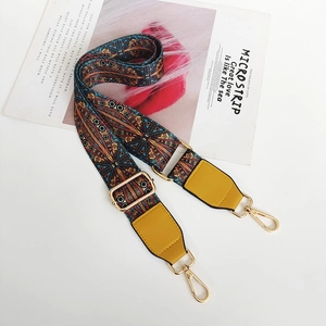 Detail of bohemian jacquard woven strap with yellow leather ends and gold metal buckles