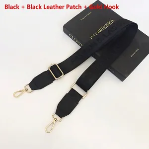 Adjustable black nylon shoulder strap with gold metal hooks and leather reinforcements