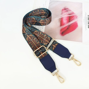 Detail of bohemian woven bag strap with colorful geometric patterns and gold metal buckle