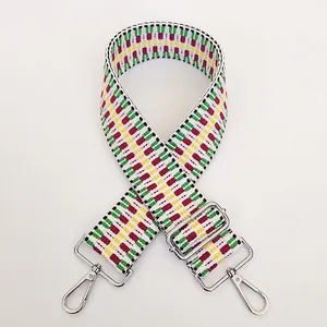 Close-up of multicolored geometric woven bag strap with silver metal lobster clasps