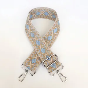 Detail view of thickened canvas strap with silver metal swivel hooks and blue geometric patterns