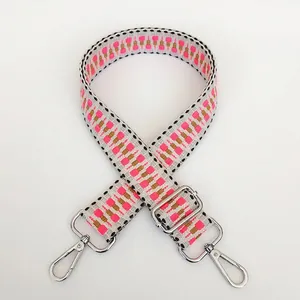 Detail of grey woven strap with pink geometric embroidery and silver metal swivel hooks