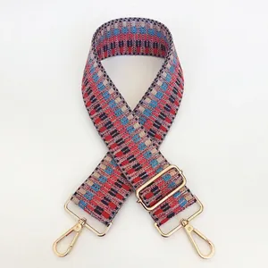 Macro detail of the colorful geometric woven bag strap with polished gold-tone metal buckles