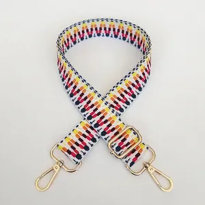 Detail of adjustable geometric woven shoulder strap with gold metal swivel snap hooks