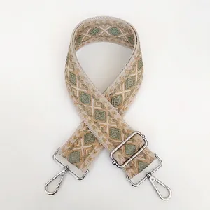 Detail view of ethnic geometric diamond pattern wide woven bag strap with silver metal hooks
