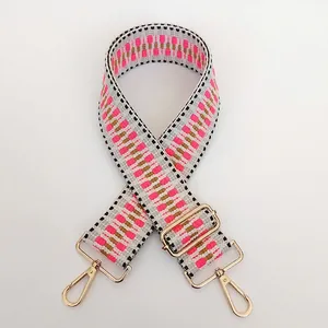 Detail of adjustable geometric woven shoulder strap with gold-tone swivel hooks