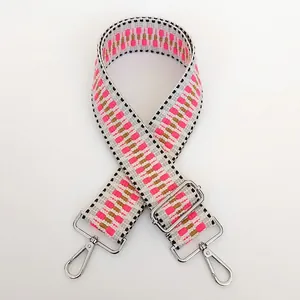 Close-up of pink and grey geometric woven shoulder strap with silver metal hooks