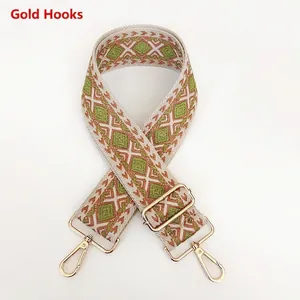 Detail view of woven jacquard bag strap with geometric diamond pattern and gold hardware