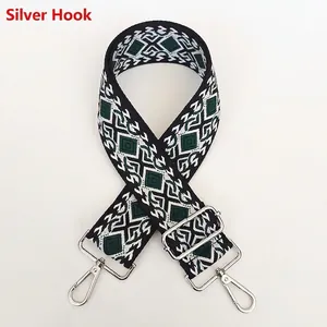 Detail of wide canvas bag strap with green geometric diamond jacquard and silver hooks