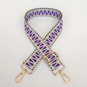 Close-up of adjustable woven shoulder strap with geometric patterns and gold lobster clasps