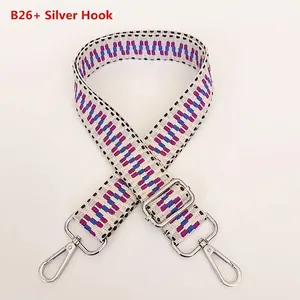 Detail of adjustable woven shoulder strap with purple geometric pattern and silver hooks