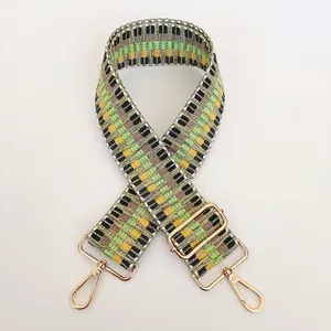 Detail of colorful geometric woven shoulder strap with gold metal hooks and adjustable buckle