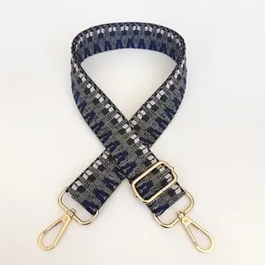 Close-up of geometric woven pattern and gold lobster clasp on adjustable bag strap