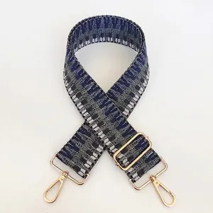 Detail of adjustable geometric woven shoulder strap with gold-tone metal swivel hooks