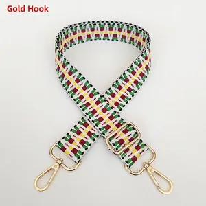 Macro detail of embroidered geometric bag strap with adjustable gold swivel metal hooks