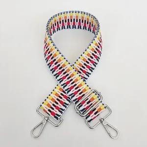 Close-up of geometric woven shoulder strap with silver hooks and adjustable buckles