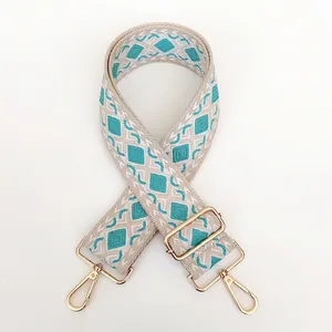 Detail view of woven guitar strap with turquoise diamond pattern and gold hook